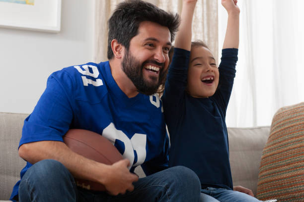istock father watching sport game with daughter 1389745796