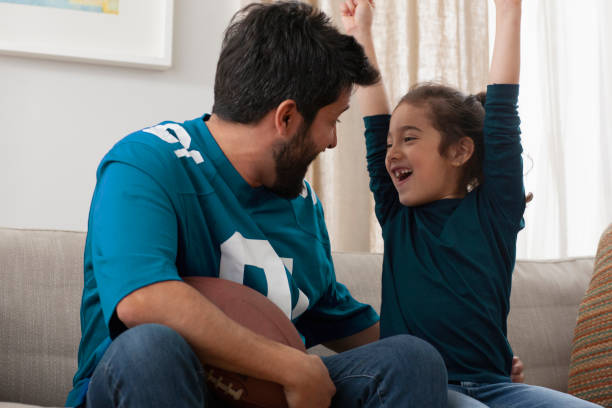 istock father watching sport game with daughter 1389745810