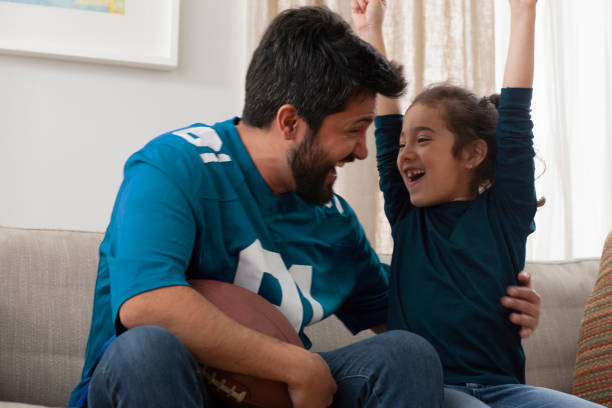 istock father watching sport game with daughter 1389745857