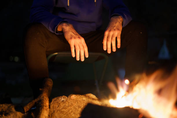 istock Unrecognizable man warming his hands at dusk by the fire. Camping concept 1389746407