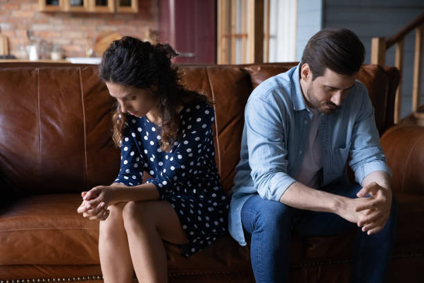 istock Frustrated married couple sit on couch after quarrel avoid talking 1389746505