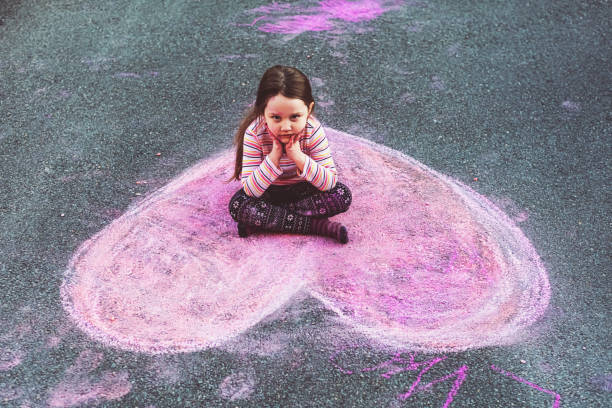 istock Girl Makes Chalk Heart Drawing 1389751706