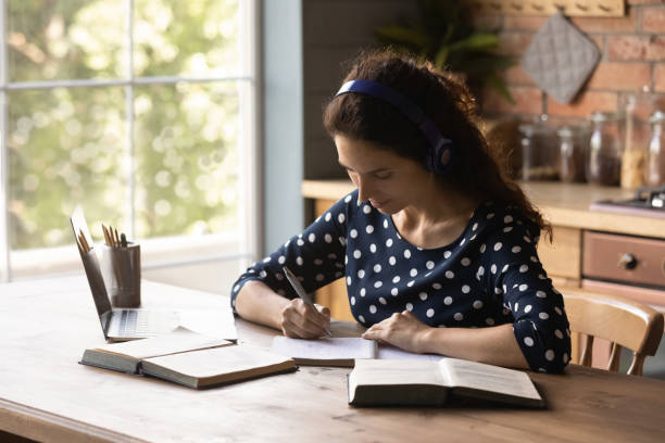 istock Focused young latin woman in headphones engaged in e learning 1389752886