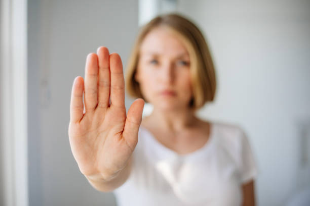 istock Strong young lady extending hand saying no to harassment abuse 1389753657
