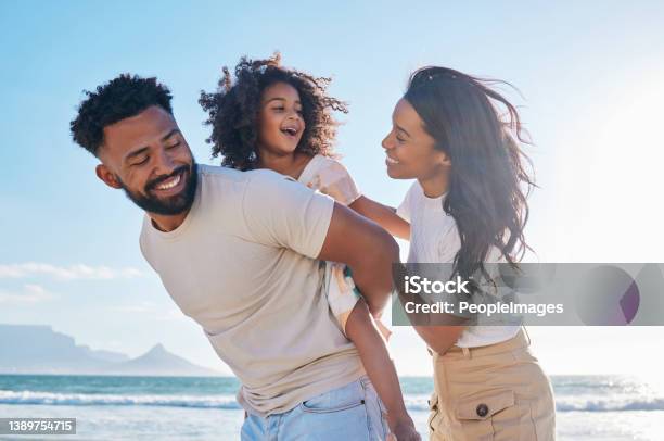 Cropped Shot Of An Affectionate Young Family Of Three Taking A Walk On The Beach Stock Photo - Download Image Now