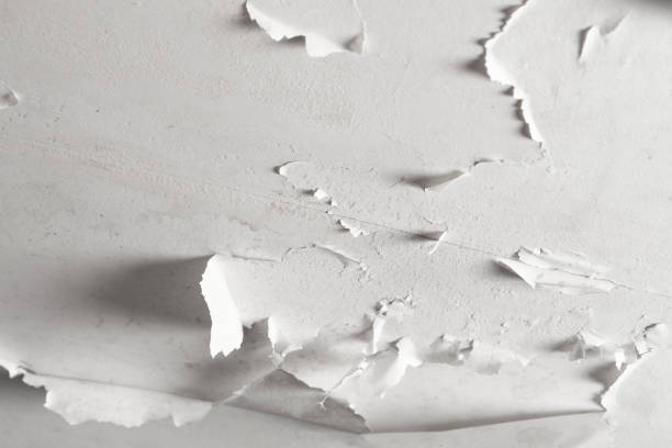 istock Damaged bathroom ceiling with cracked and peeling white paint on painted drywall close-up 1389755516