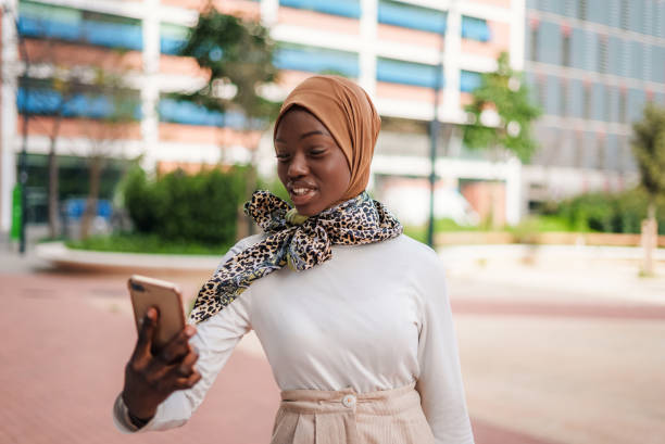istock Smiling black Muslim lady checking message on smartphone 1389755897