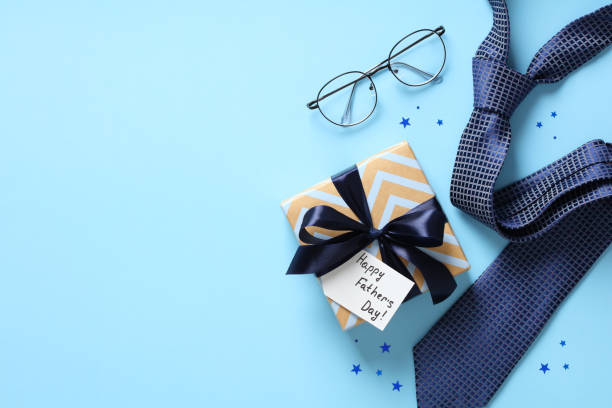 istock Happy Fathers Day concept. Flat lay composition with vintage gift box, eyeglasses, necktie on blue background. 1389757209