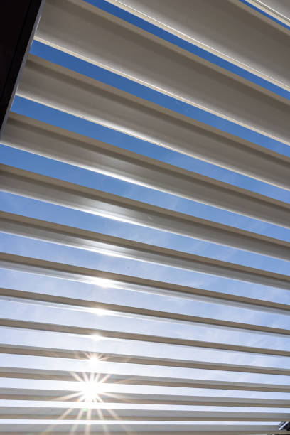 istock Trendy outdoor patio pergola with sun's rays passing through the metallic structure 1389758482