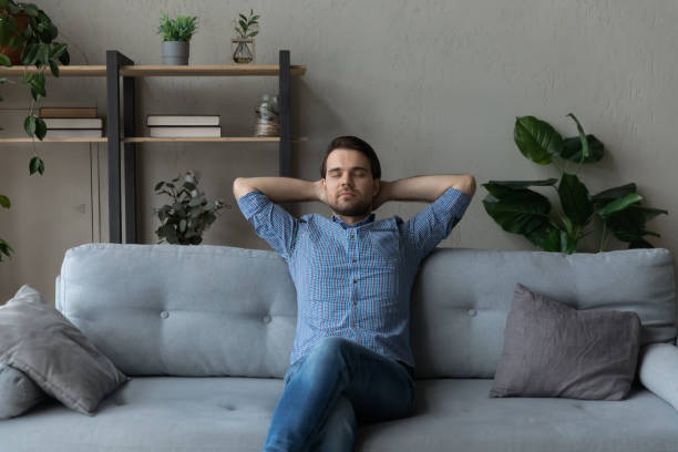 istock Calm single man relaxing on cozy sofa at home 1389758518