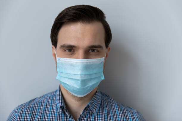 istock Man wear face mask looking at camera posing indoor 1389758533