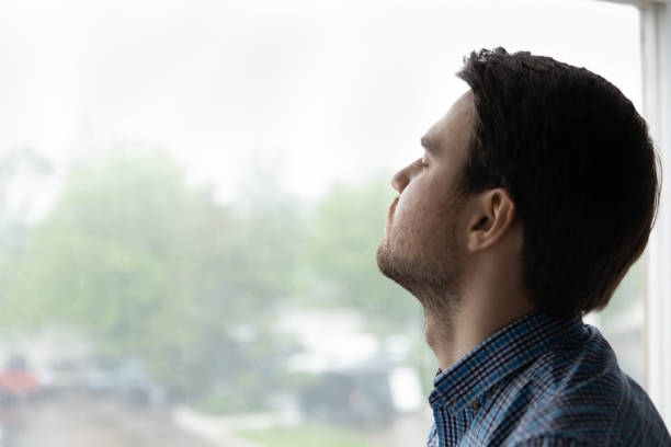 istock Young man closed his eyes pose on window background 1389758536