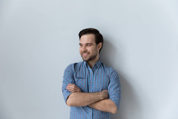 istock Young man in casual shirt pose on gray studio background 1389758539