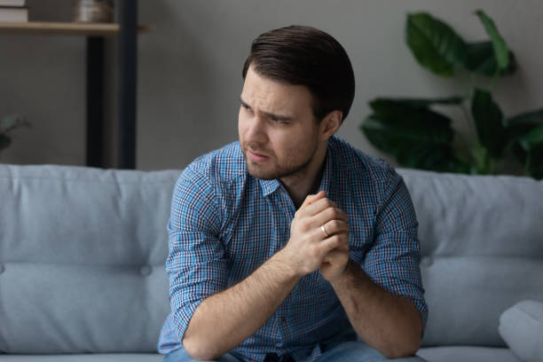 istock Man having mental pain, sit on sofa looks into distance 1389758556