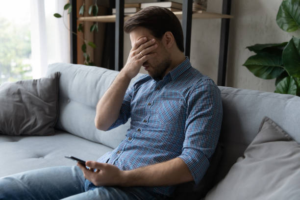 istock Sad man holds smartphone suffering from relations break up message 1389759787