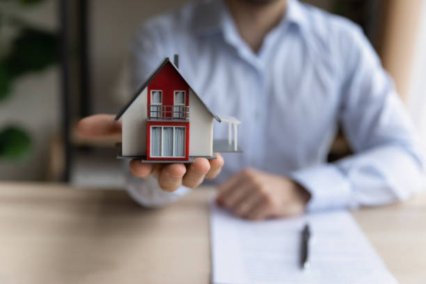Man Real Estate Agent holding tiny house layout close up view