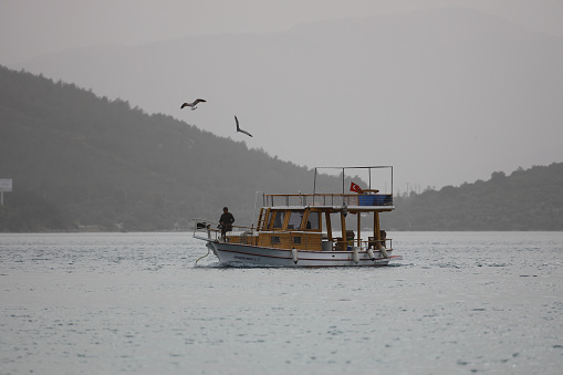 Bodrum, Mugla, Turkey. 03 April 2022. In the desert dust-covered skies, the fishermen who sailed for the weekend are returning. Even the sun is not visible because of the polluted air.