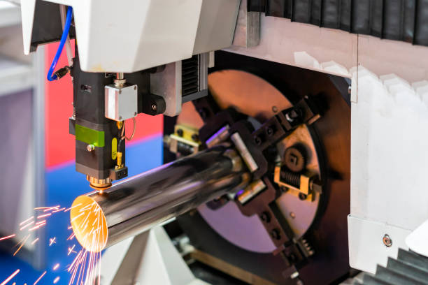 istock close up nozzle component of high precision cnc plasma laser cutting machine during engrave or perforate workpiece (pipe) and many sparks with automatic feed and rotation 