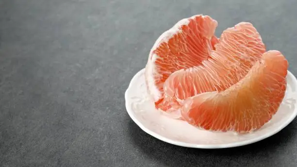 Photo of Pomelo Fruit on Plate. Grapefruit, jeruk Bali, or Bali Pomelo Fruit. Large Oranges in Indonesia are known as Bali Oranges or Jeruk Bali.