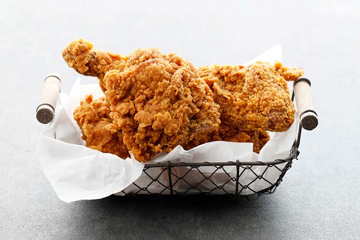 Homemade Crispy Fried Chicken on Wire Basket, Isolated on White. Close Up