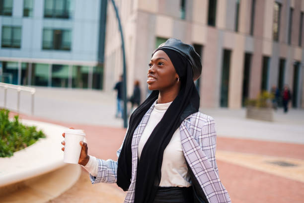 istock Cheerful black lady with takeaway beverage in park 1389767068