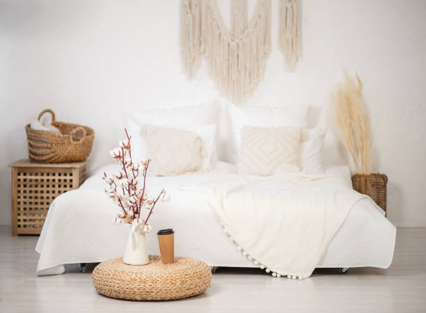 spacious room with a trendy loft design of bedroom area. huge windows and stylish wicker light furniture inside. an abundance of ethnic decor stock photo