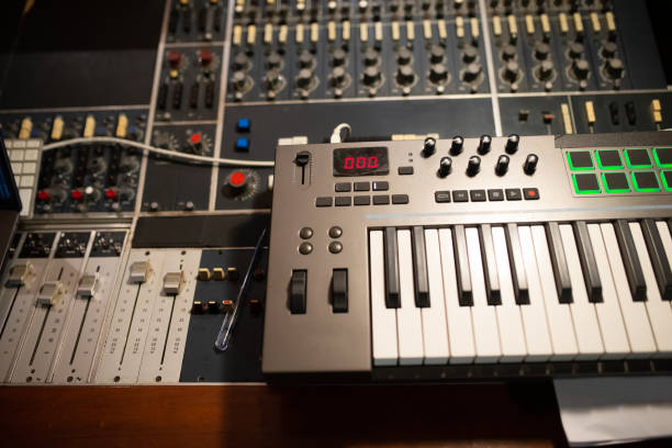 The Best Synthesizers for Every Music Production Style 11 mixing console panel and keyboard in sound recording studio