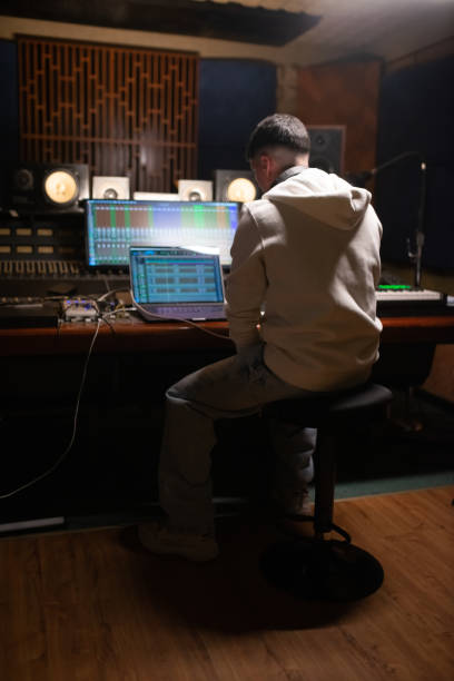 istock Rear view of young sound engineer looking at laptop 1389772842