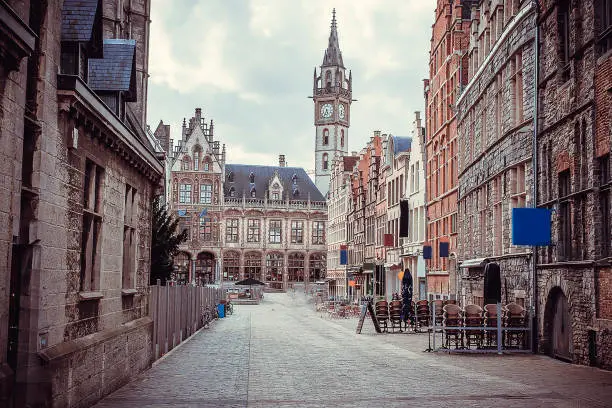 Photo of photos of some streets of the city of Ghent in Belgium. In the photos you can see streets, sidewalks, old residential areas, bricks, sky, windows, canals, bridges, rivers, bicycles, medieval era, flowers, modern structures, geometry