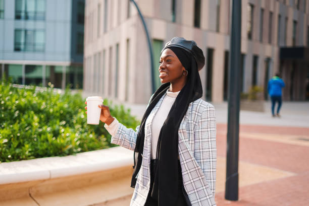 istock Cheerful black lady with takeaway beverage in park 1389778929