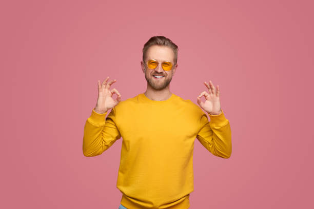 istock Cheerful man showing OK gesture and looking at camera 1389780180