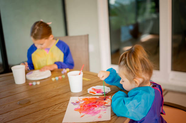 istock Siblings Painting at Patio Table 1389783360