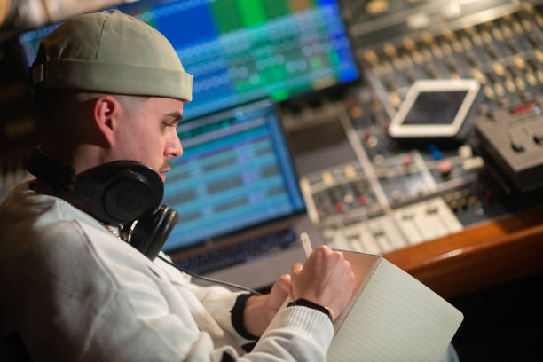 istock Concentrated young music producer taking notes in notepad 1389783628