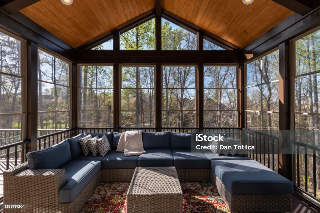 Contemporary Porch Enclosure in Springtime Contemporary screened porch in springtime, full of blooms trees in the background. Conservatory - Sun Room Stock Photo
