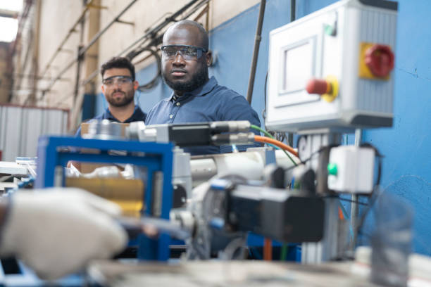 istock Multiracial workers operating equipment at solar panel factory 1389793628