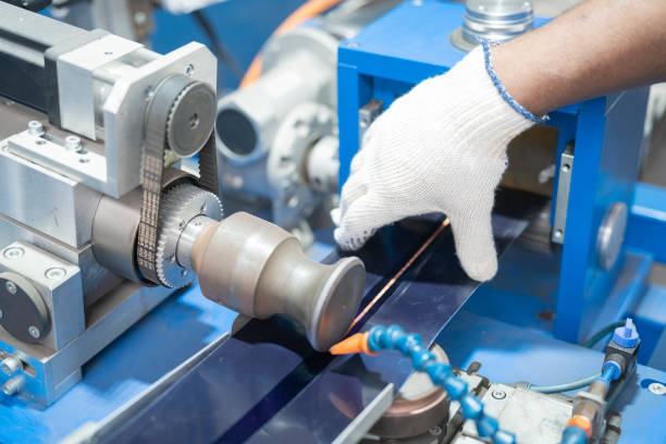 Hand detail of worker operating assembly machine at solar panel factory
