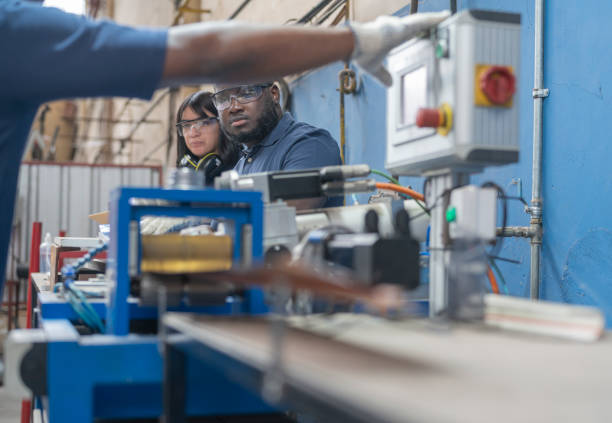 istock Multiracial workers operating equipment at solar panel factory 1389793648