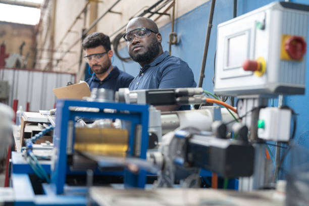 istock Multiracial workers operating equipment at solar panel factory 1389793650