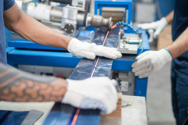 close-up of hands of workers operating assembly machine at solar panel factory - protective glove machinist human hand african descent imagens e fotografias de stock