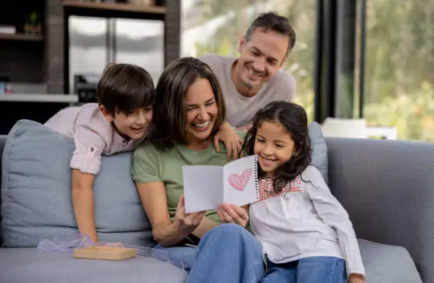 Photo of Loving family celebrating Mother's Day at home wih a beautiful card