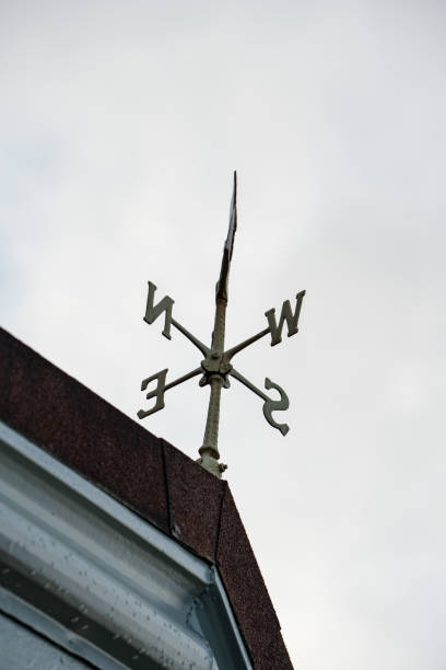 rustikaler pfeil wetterfahne mit windrichtung ost, west, nord und süd. - roof roof tile rooster weather vane stock-fotos und bilder