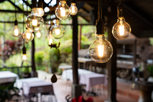 a relaxing mood lamp with tungsten filament hanging inside an alfresco indoor restaurant