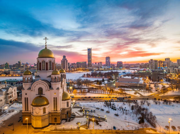 зимний екатеринбург и храм на крови в красивом розово-оранжевом закате. перевод текста о храме: честна перед господом смерть его святых. - екатеринбург стоковые фото и изображения