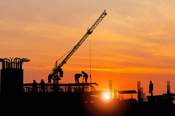 istock Silhouette of Foreman worker team at construction site with blurred sunset sky background 1389805621