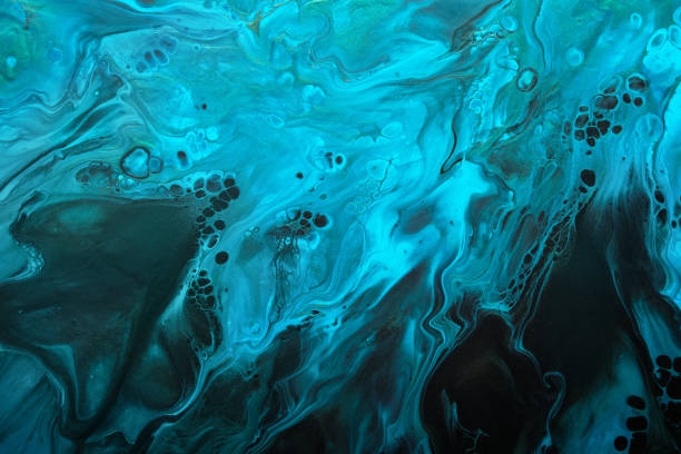 istock Fluid Art. Fluorescent blue waves with golden particles on black background. Marble effect background or texture 1389808659