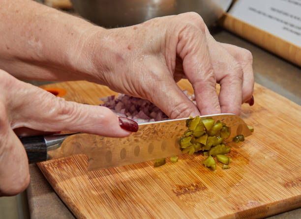 istock Chef cuts pickles with knife to prepare everything according to the recipe 1389811370