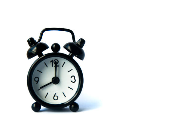 istock Black alarm clock isolated on white background. The clock set at 8 o'clock. 1389815247