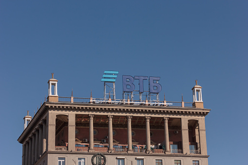 Moscow, Russia - March 19, 2022: View of vTB Bank logo sign on roof of old USSR building