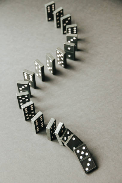 istock Black dominoes chain on table background 1389821730