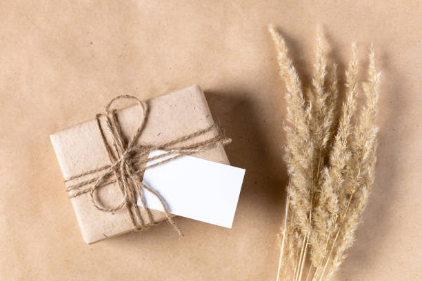 istock empty white gift tag mock up on craft paper box with dried spikelets decoration on natural beige background. 1389823952